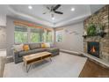 Cozy living room with stone fireplace, a neutral sectional sofa, and natural light at 24028 E Caleb Pl, Aurora, CO 80016
