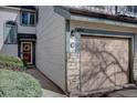 Charming home exterior featuring a single-car garage, stone accents, and a welcoming entryway adorned with a wreath at 8354 S Everett Way # C, Littleton, CO 80128