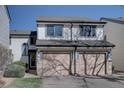 Townhouse exterior featuring two single-car garages, stone accents, and inviting entryway, surrounded by landscaping at 8354 S Everett Way # C, Littleton, CO 80128
