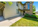 Home exterior featuring stone accents, green lawn, and a walkway leading to the entrance at 13020 Grant W Cir # A, Thornton, CO 80241