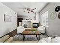 Cozy living room featuring a fireplace, ceiling fan, and two comfortable armchairs at 13020 Grant W Cir # A, Thornton, CO 80241