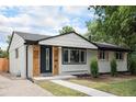 Well-maintained home showcasing light grey brick and wood accents, complemented by a manicured lawn at 530 Everett St, Lakewood, CO 80226