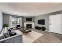 Inviting living room featuring a fireplace, gray walls, and modern decor and balcony access at 3480 S Eagle St # 101, Aurora, CO 80014