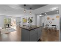 Open kitchen boasts a gray island, granite countertops, and modern pendant lighting at 610 S Clinton St # 10A, Denver, CO 80247