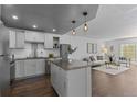 Bright kitchen with white cabinets, stainless steel appliances, and center island open to living area at 610 S Clinton St # 10A, Denver, CO 80247