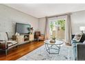 Cozy living room boasts hardwood floors, modern decor, and a sliding glass door to the outdoor space at 1060 S Parker Rd # 25, Denver, CO 80231