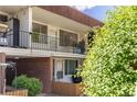 A condo building featuring balconies, red brick accents, and a well-manicured lawn at 10185 W 25Th Ave # 33, Lakewood, CO 80215