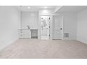 Finished basement area featuring new neutral carpet, a wet bar, and bathroom access at 1346 N Knox Ct, Denver, CO 80204