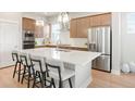 Modern kitchen with stainless steel appliances, large island, and stylish pendant lighting at 21209 E 62Nd Ave, Aurora, CO 80019