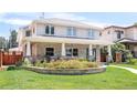 Charming two-story home featuring stone accents, a covered porch with seating, and a beautifully landscaped front yard at 1644 S Garfield St, Denver, CO 80210