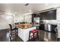 Contemporary kitchen with stainless steel appliances, dark cabinetry, granite countertops, and a large center island at 18651 E 53Rd Ave, Denver, CO 80249