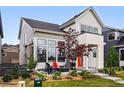 Charming home with an orange front door, covered porch, and well-manicured landscaping at 6237 Stable View St, Castle Pines, CO 80108