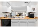 Bright kitchen featuring white cabinets and wood countertops, seamlessly connecting to the cozy living room with a fireplace at 16001 E Alaska Pl # 12, Aurora, CO 80017