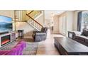 Bright living room with hardwood floors, staircase, and a stylish modern electric fireplace at 7925 W Layton Ave # 500, Littleton, CO 80123