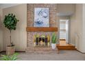 Brick fireplace with a wood mantel and brass fire screen in the living room at 8111 S Marion Ct, Centennial, CO 80122