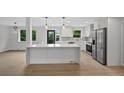 Modern kitchen with white cabinets, marble countertops, stainless steel appliances, and a large center island at 9025 W 4Th Ave, Lakewood, CO 80226