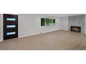 Bright living room featuring hardwood floors, a tiled fireplace, and a large window with neighborhood views at 9025 W 4Th Ave, Lakewood, CO 80226
