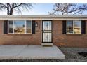 Close-up of the brick facade, front door with decorative security screen, and well-kept yard at 7891 Maria St, Westminster, CO 80030