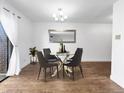 Bright dining area featuring hardwood floors, modern lighting, round table with four chairs and view to the side at 480 S Marion Pkwy # 1202, Denver, CO 80209