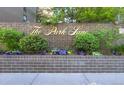 The Park Lane sign sits in front of a brick retaining wall lined with landscaping and colorful flowers at 480 S Marion Pkwy # 1202, Denver, CO 80209