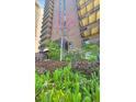 Well maintained landscaping features the building exterior with lovely foliage and a blooming tree at 480 S Marion Pkwy # 1202, Denver, CO 80209
