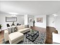 Inviting living room featuring a neutral sectional, modern coffee table, and hardwood flooring at 480 S Marion Pkwy # 1202, Denver, CO 80209