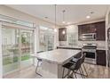 Bright kitchen with granite countertops, stainless steel appliances, a center island and sliding glass door to the backyard at 18112 E 104Th Way, Commerce City, CO 80022