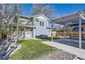 Two story home featuring a well-manicured lawn, carport, and partial driveway leading to the attached garage at 4441 N Meade St, Denver, CO 80211