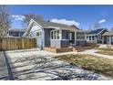 Charming home with gray exterior, brick accents, green door, and a spacious driveway on a sunny day at 4441 N Meade St, Denver, CO 80211