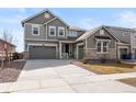 Beautiful two-story home with gray siding, stone accents, and a spacious three car garage at 5072 Lake Port Ave, Firestone, CO 80504