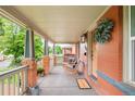 Charming front porch with cozy rocking chairs, a 'welcome' mat, and brick accents at 3864 Osceola St, Denver, CO 80212