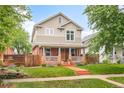 Charming two-story home with inviting front porch, manicured lawn, and colorful garden at 3864 Osceola St, Denver, CO 80212