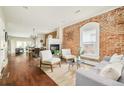 Bright living room featuring exposed brick wall, fireplace, and hardwood floors at 3864 Osceola St, Denver, CO 80212