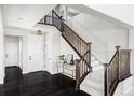 Elegant entryway with dark hardwood floors and a wooden staircase at 6918 S Riverwood Way, Aurora, CO 80016