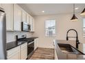 Bright kitchen featuring stainless steel appliances, modern cabinetry, and a sleek black faucet at 2491 W 69Th Pl, Denver, CO 80221