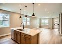 Open kitchen featuring a large island, stainless steel dishwasher, and hardwood floors at 2491 W 69Th Pl, Denver, CO 80221
