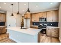 Modern kitchen featuring stainless steel appliances, a spacious island, and elegant pendant lighting at 2491 W 69Th Pl, Denver, CO 80221