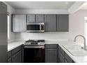 Updated kitchen featuring stainless steel appliances and sleek gray cabinets at 7680 Elmwood St, Littleton, CO 80125