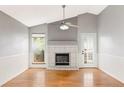 Bright living room featuring a fireplace, ceiling fan, and hardwood floors at 7680 Elmwood St, Littleton, CO 80125