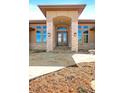 Grand front entrance features stone columns, an arched doorway, a stone path and double wood doors at 1552 Colt Cir, Castle Rock, CO 80109