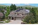 Charming two-story home with lush landscaping, a stone and stucco facade, and solar panels at 5448 El Diente St, Golden, CO 80403