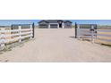 Wide shot of property's gate leading up to home with open rural landscape at 56159 E Tomahawk Ave, Strasburg, CO 80136