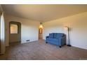 Neutral living room shows carpet flooring, arched doorway, and a comfortable blue sofa at 971 Elm Pl, Thornton, CO 80229