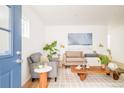 Cozy living room with a plaid armchair, a neutral sofa and a rustic coffee table with decor at 2992 Hooker St, Denver, CO 80211