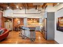 Open-concept living room with exposed brick walls, wood floors, bar seating, and modern kitchen at 1801 Wynkoop St # 518, Denver, CO 80202