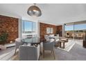 Bright living room with brick accent wall, dining area and sliding glass doors leading to a balcony at 850 20Th St # 503, Boulder, CO 80302