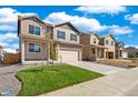 Two-story home with blue shutters, a two car garage, and a newly landscaped yard at 18813 E 99Th Ave, Commerce City, CO 80022