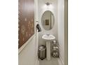 Stylish powder room featuring a pedestal sink, oval mirror, and modern decor at 18813 E 99Th Ave, Commerce City, CO 80022