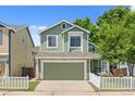Charming two-story home with green siding, well-maintained lawn, and attached two-car garage at 1359 S Beeler Ct, Denver, CO 80247