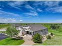 Beautifully landscaped home with a three-car garage surrounded by a green lawn under a bright blue sky at 2504 Elkhorn Ranch St, Parker, CO 80138